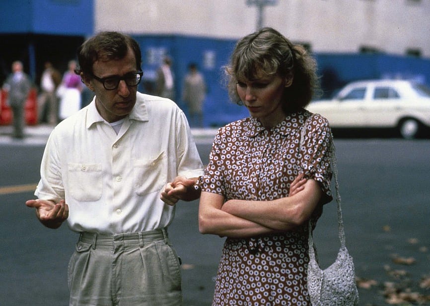 A man and woman walk down the street talking.