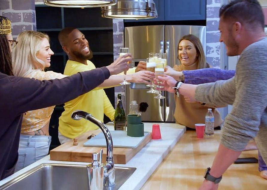 Members of The Real World cast in a kitchen