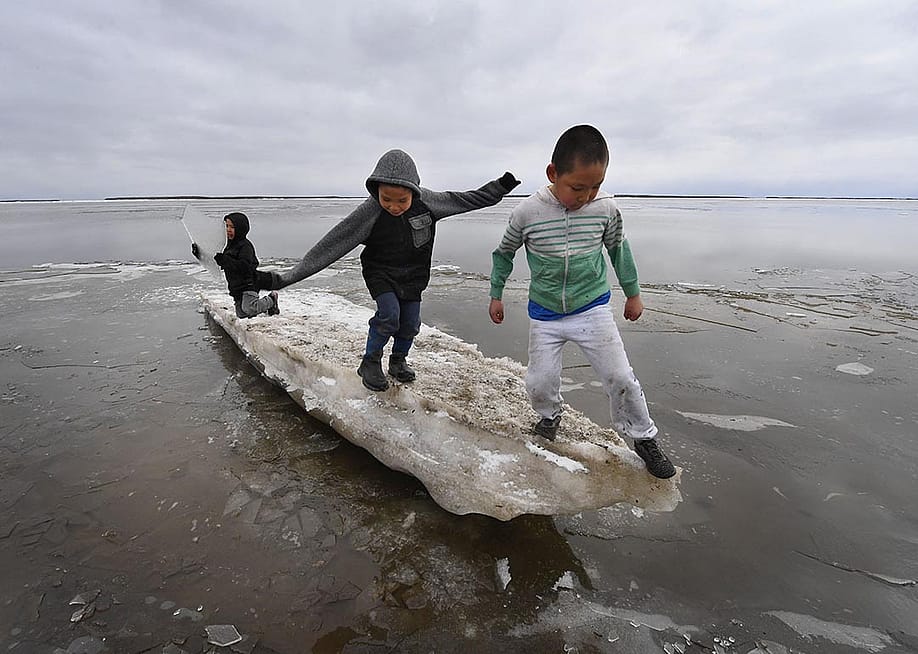 Schoolchildren play on melting ice at the climate change affected Yupik village of Napakiak on the Yukon Delta in Alaska on April 18, 2019. — MARK RALSTON // AFP via Getty Images