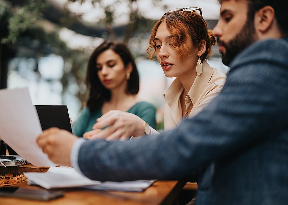 Three startup business colleagues discussing during a casual coffee meeting. — Gorgev // Shutterstock