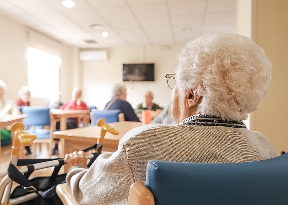 Elderly woman in a nursing home activity area. — Daniel Megias // Shutterstock