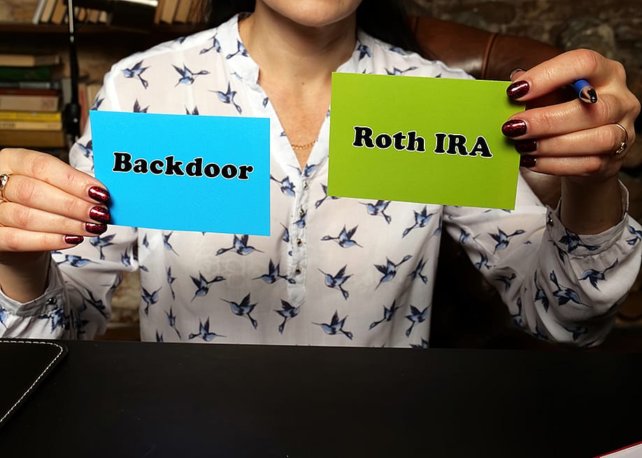 Person holding up two notes with "backdoor" and "Roth IRA" written on each. — Yuriy K // Shutterstock