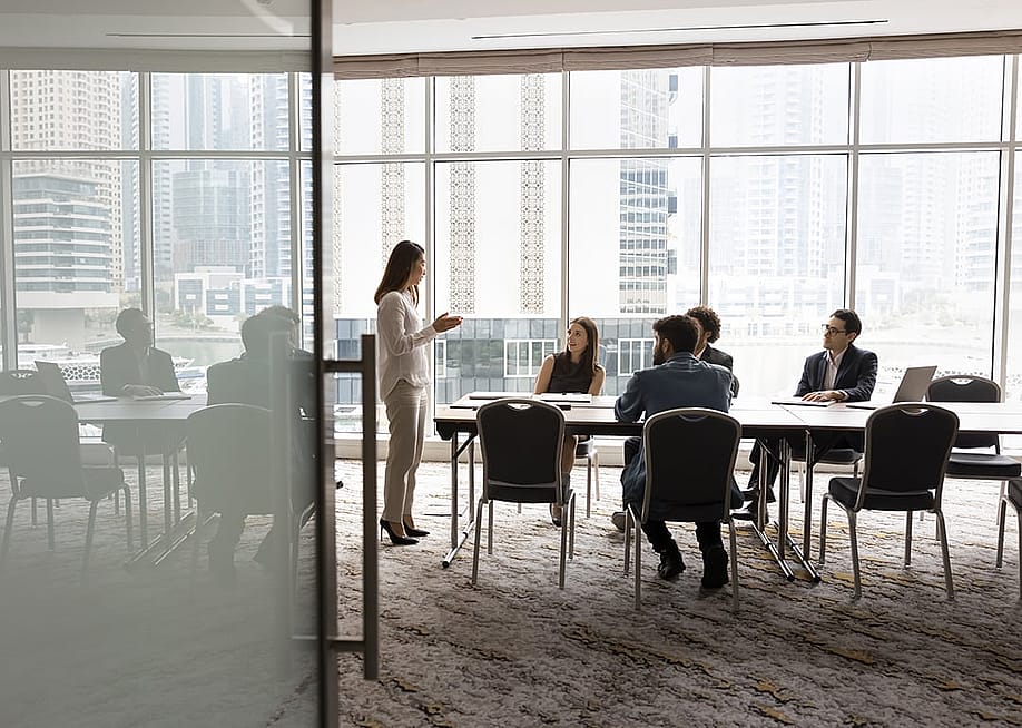 A business team engaged in a discussion in a meeting room. — fizkes // Shutterstock