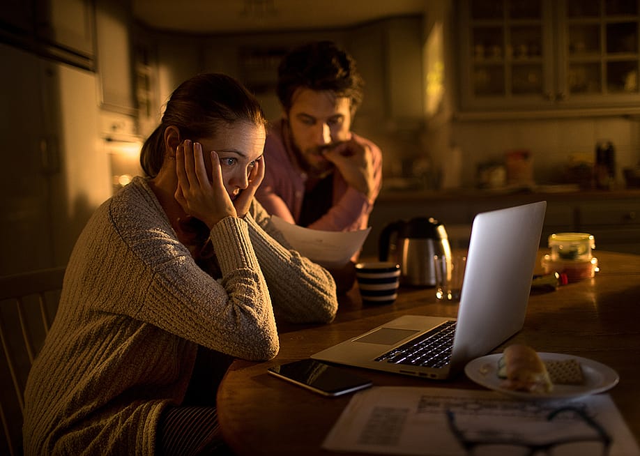 Young couple stressfully looking at their laptop. — Geber86 // Shutterstock