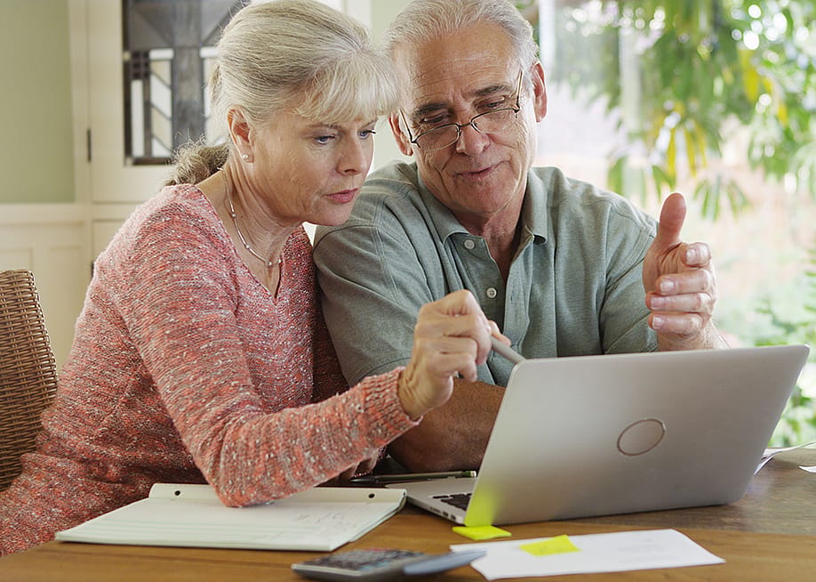 Rocketclips, Inc. // Shutterstock — A senior couple using a laptop to compute expenses.