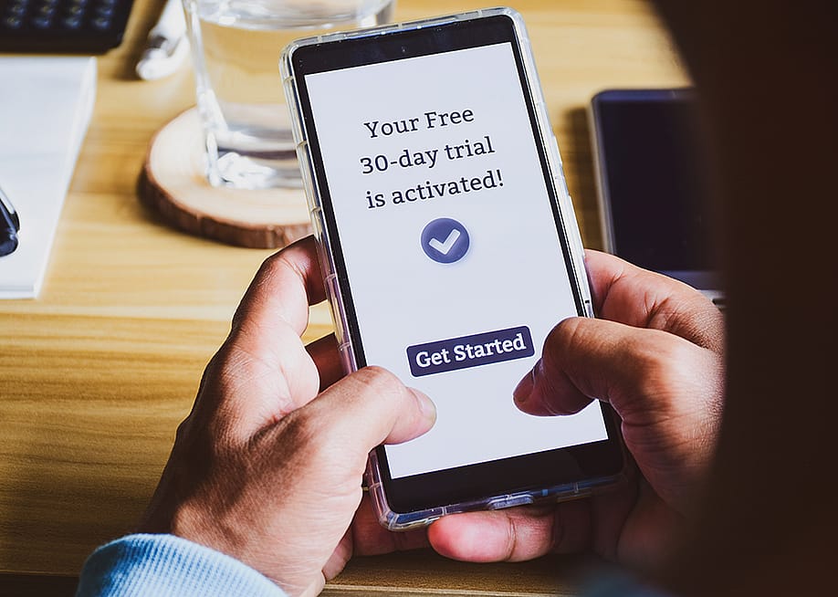 A user is seen activating a 30-day free trial of an app. — Linaimages // Shutterstock