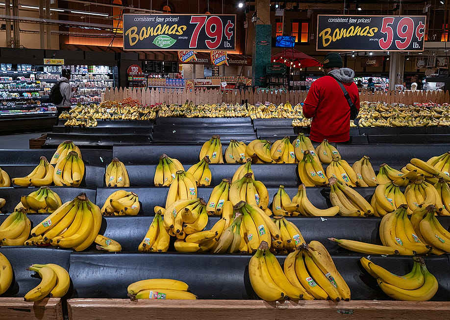 Staff stocking up the organic bananas aisle with a large low prices sign at a grocery store in Brooklyn, New York. — Spencer Platt // Getty Images