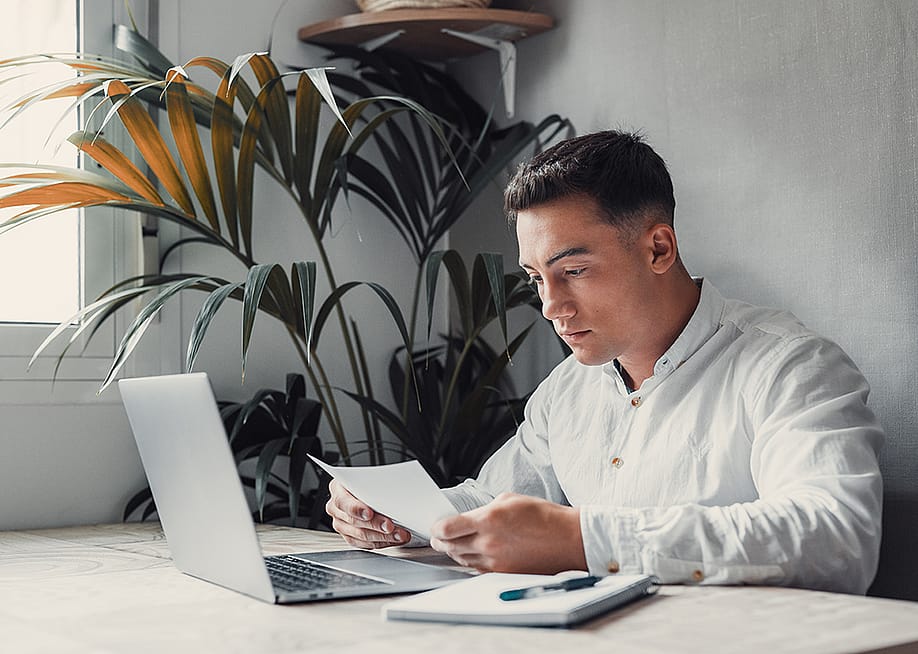 A confused young college student reading a debt letter. — Perfect Wave // Shutterstock