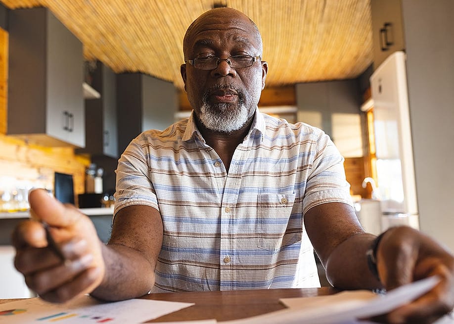 Senior man staring and signing finance documents. — wavebreakmedia // Shutterstock