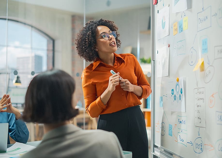Businesswoman leading a presentation to her creative team. — Gorodenkoff // Shutterstock