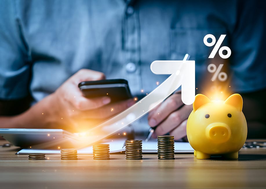 A business professional calculating and saving finances illustrated with increasing interest rates graphics. — Sutthiphong Chandaeng // Shutterstock