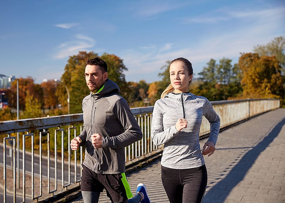 A couple running outdoors in the morning. — Ground Picture // Shutterstock