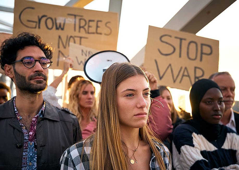 A group of diverse people protesting against war in silence outdoors. — CarlosBarquero // Shutterstock