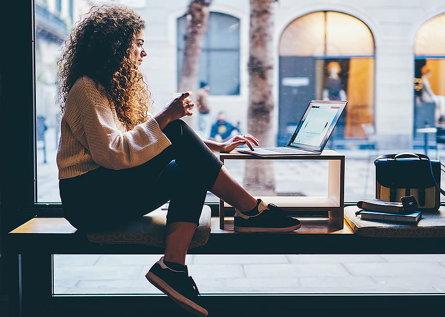 Young woman working by the window of a coworking space. — GaudiLab // Shutterstock