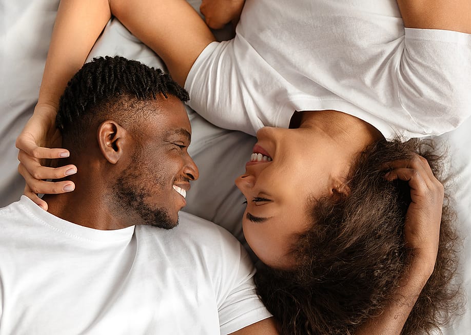 A black couple enjoying intimacy in bed. — Prostock-studio // Shutterstock