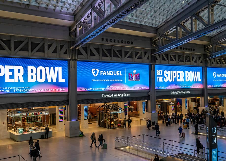 Ads for FanDuel, an online sports gambling copany, displayed on huge screens in the Moynihan Train Hall of Pennsylvania Station prior to the Super Bowl. — rblfmr // Shutterstock