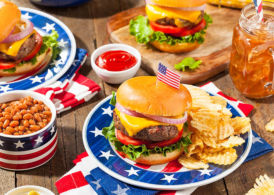 A set of homemade Fourth of July picnic meal such as burger, fries, and beans. — Brent Hofacker // Shutterstock