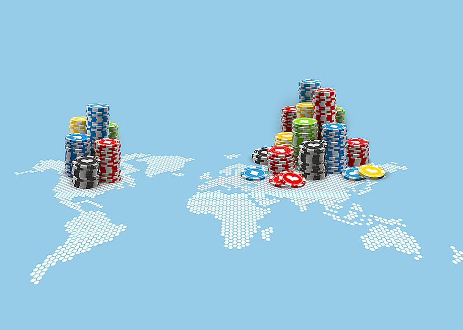 Colored casino chips on an illustration of the world map. — Volonoff // Shutterstock