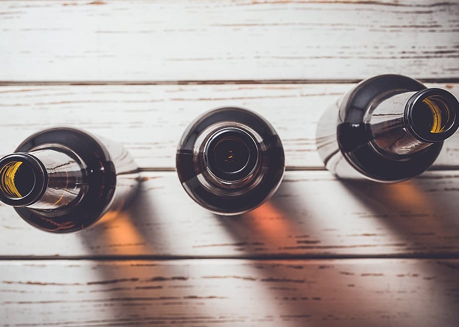 Beer bottles on an old wooden table. — Leszek Czerwonka // Shutterstock