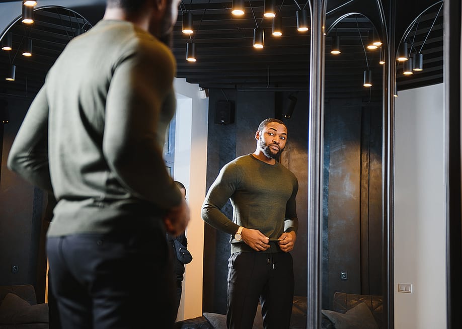 A stylish man looking in front of the mirror to check his outfit. — Hryshchyshen Serhii // Shutterstock