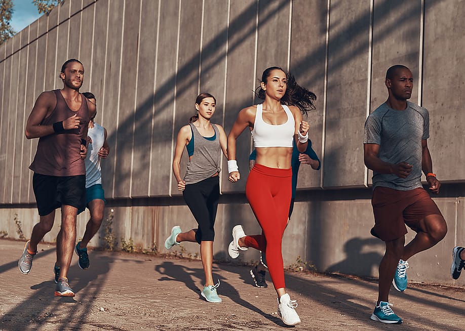 A group of people jogging outdoors. — G-Stock Studio // Shutterstock