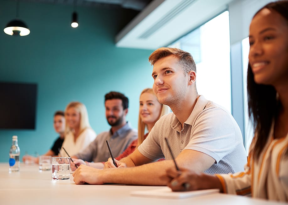 A group of post-graduate candidates in a boardroom. — Monkey Business Images // Shutterstock