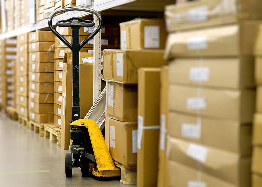 A manual pallet jack in a warehouse aisle. — Andrey Mihaylov // Shutterstock