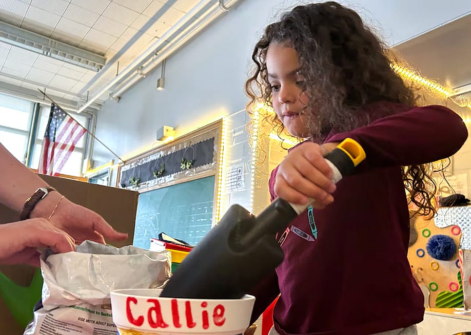 A preschooler at Palmer Elementary in Denver prepares to plant wildflowers in a pot she decorated. — Ann Schimke // Chalkbeat