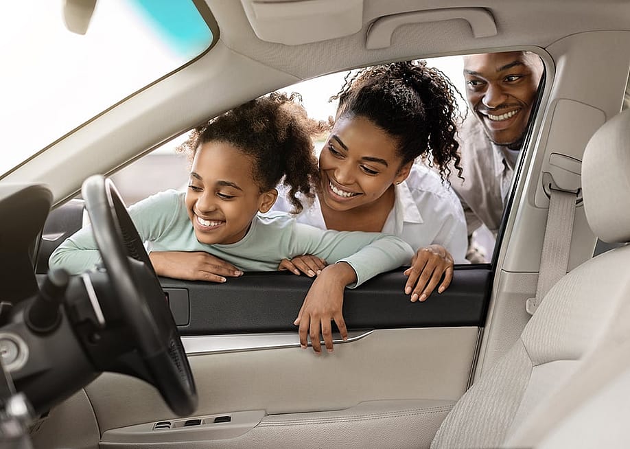 A family looking at the interior of a new car through its window. — Prostock-studio // Shutterstock
