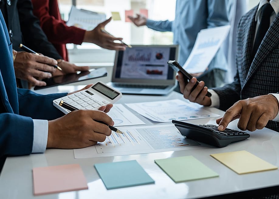Business team in a busy meeting discussing figures and reports. — R Photography Background // Shutterstock