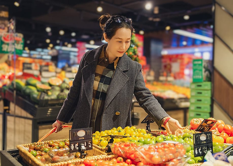 Young woman selecting fresh produce at the grocery store. — 4045 // Shutterstock