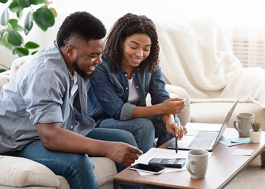 A black couple engaged in a discussion about finances. — Prostock-studio // Shutterstock