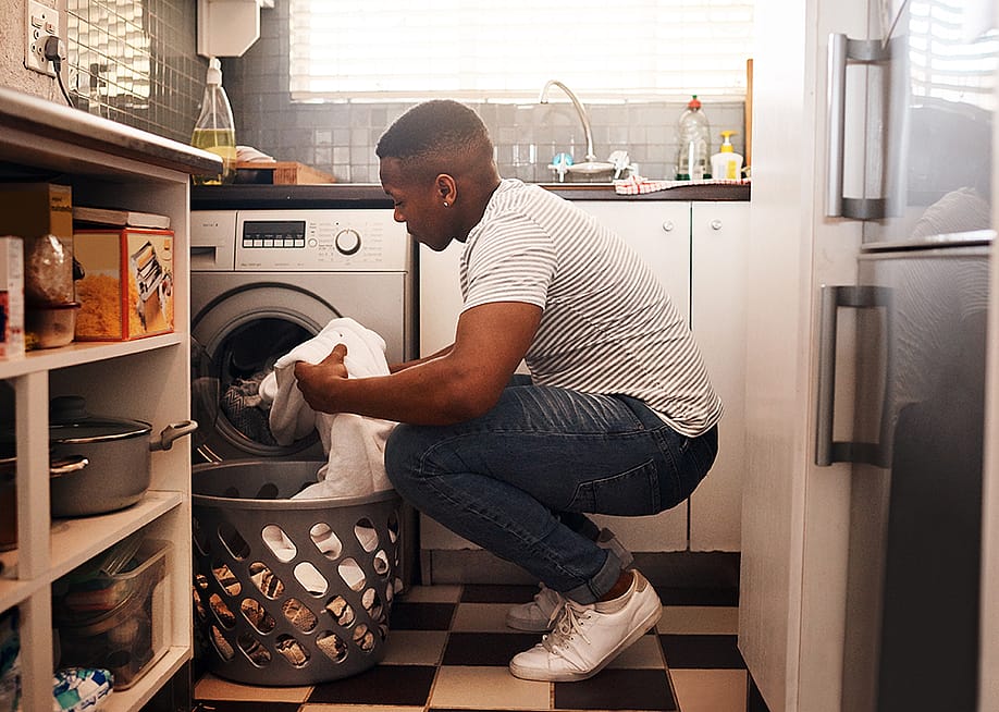 Man doing laundry at home. — PeopleImages.com - Yuri A // Shutterstock