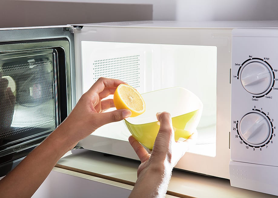 Microwave being cleaned with water and lemon. — Andrey_Popov // Shutterstock