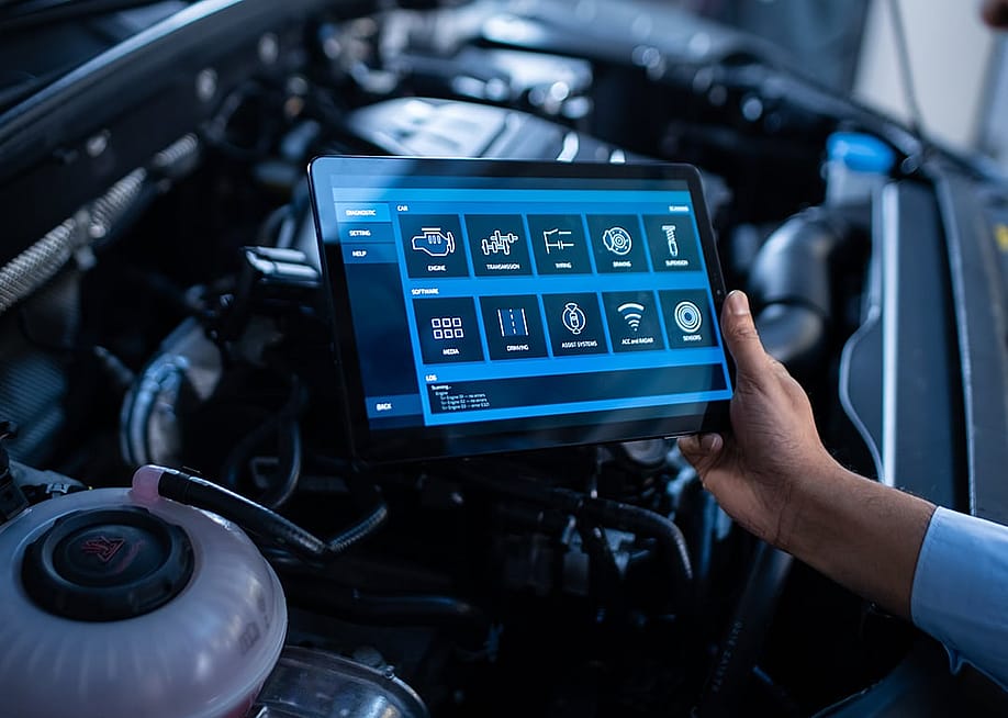 A mechanic using a tablet to configure a car's issue and repair. — Gorodenkoff // Shutterstock