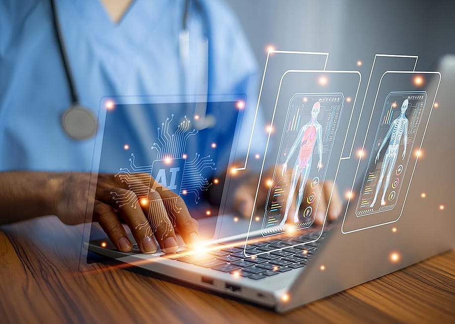 Medical professional using laptop with images symbolizing the use of AI overlaid on top. — MUNGKHOOD STUDIO // Shutterstock