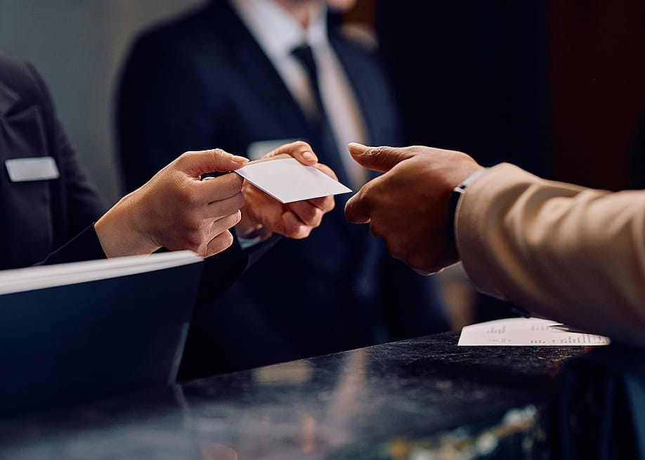 Hotel guest receiving a card key at the hotel reception. — Drazen Zigic // Shutterstock
