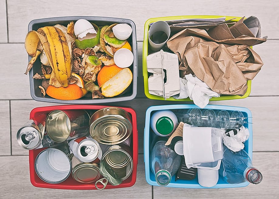 Four different container for sorting garbage for plastic, paper, metal and organic waste — Skylines // Shutterstock