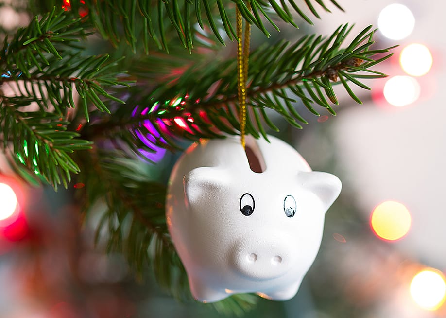 Piggy bank ornament on a Christmas tree. — udra11 // Shutterstock