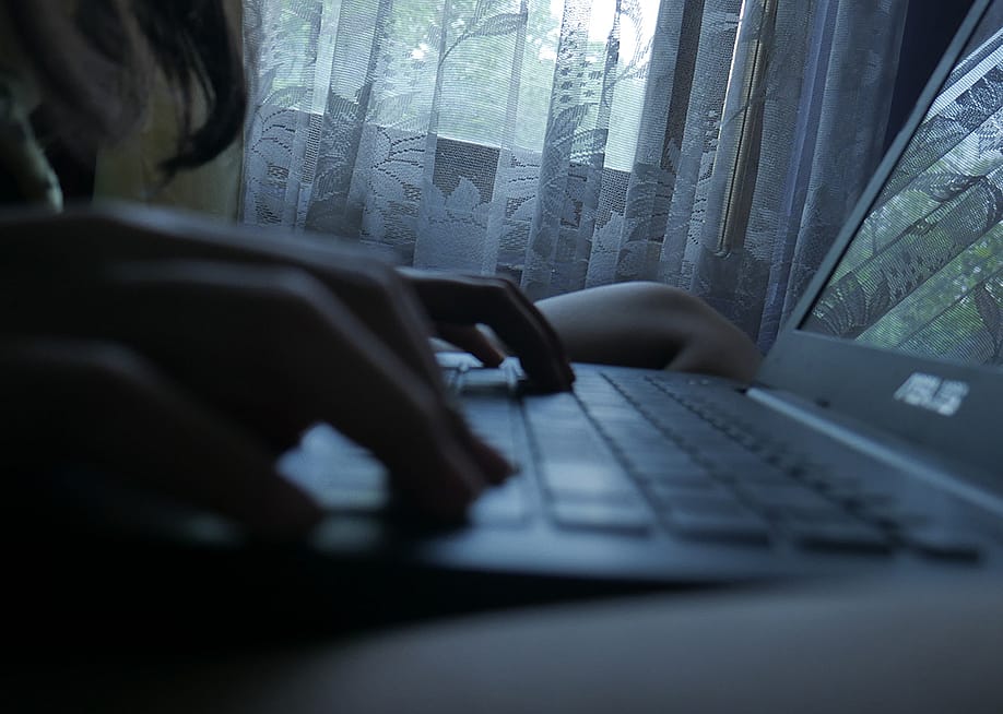 Silhouette of a person typing on a laptop at home. — Yehez.Picture // Shutterstock