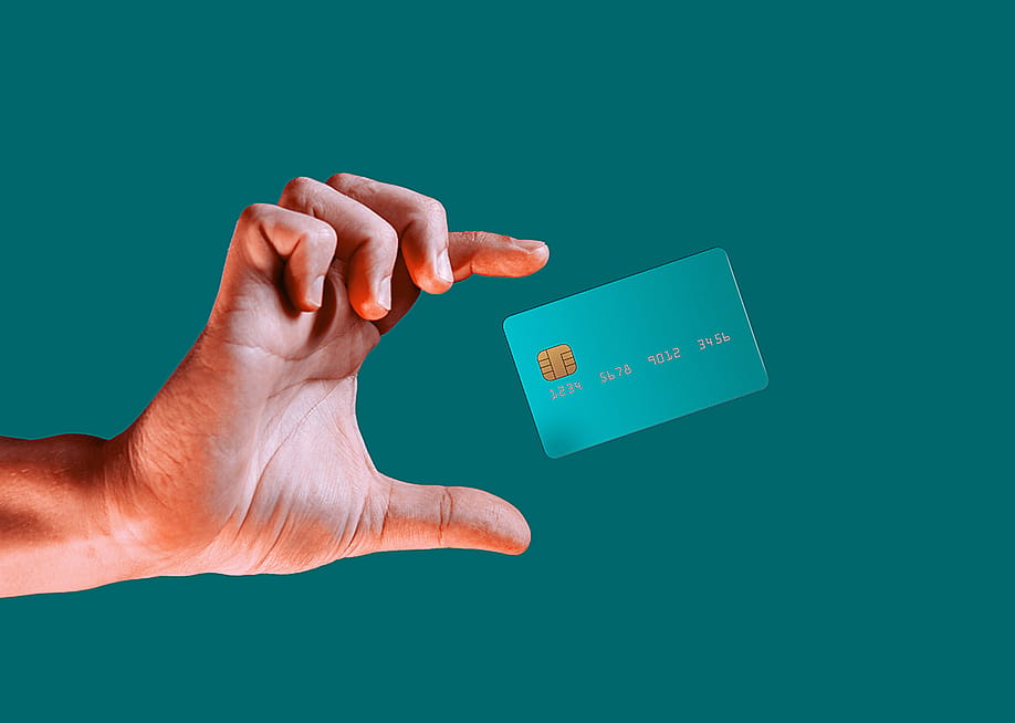 Hand reaching for a credit card mid-air. — Geobor // Shutterstock