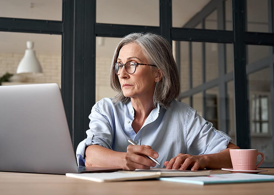 Senior woman looking up information online and writing notes. — Ground Picture // Shutterstock