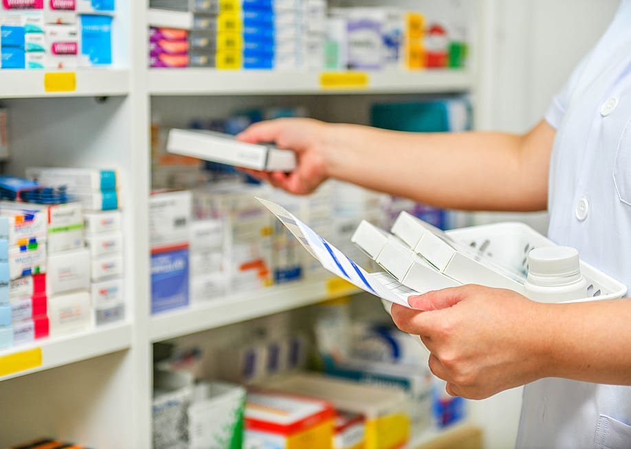 A pharmacist filling prescription at a pharmacy. — i viewfinder // Shutterstock