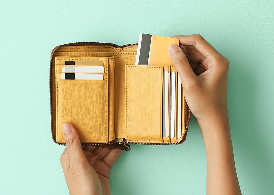 Person taking out a credit card from a wallet. — Melimey // Shutterstock