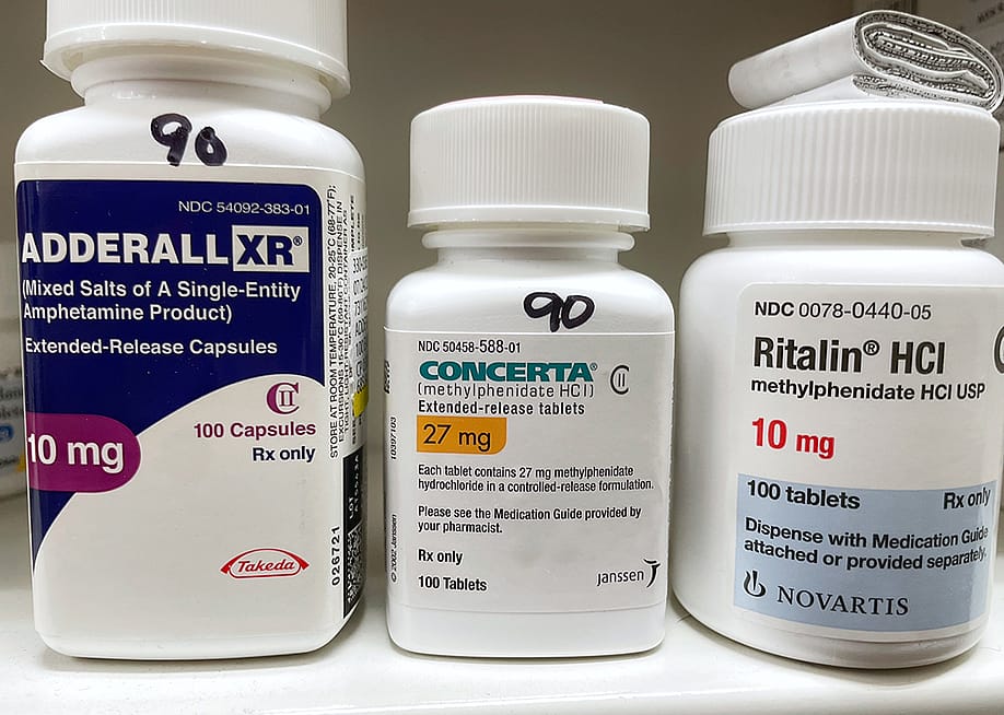 Bottles of ADHD medications such as Adderall, Concerta, and Ritalin. — PureRadiancePhoto // Shutterstock