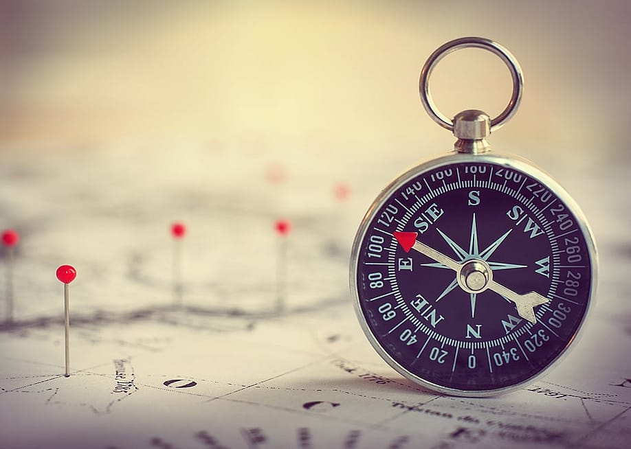 Magnetic compass on a world map. — Triff // Shutterstock