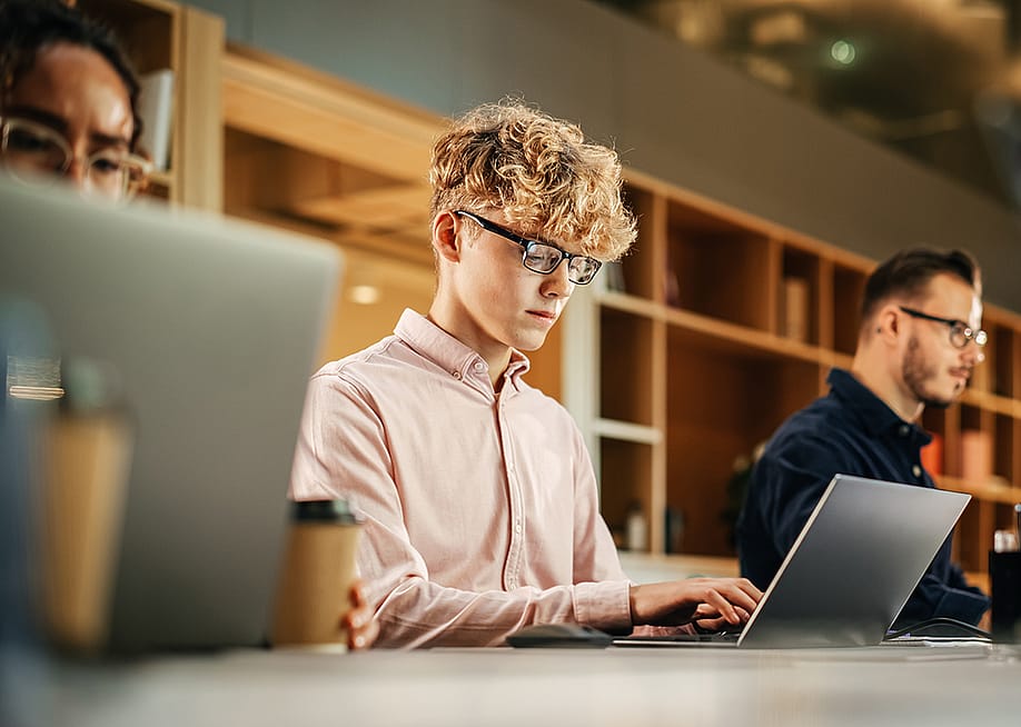 A group of software engineers working using their laptops. — Gorodenkoff // Shutterstock