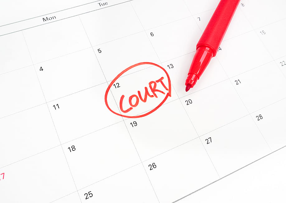The word "court" encircled on a calendar's date. — Jessica Jeong // Shutterstock