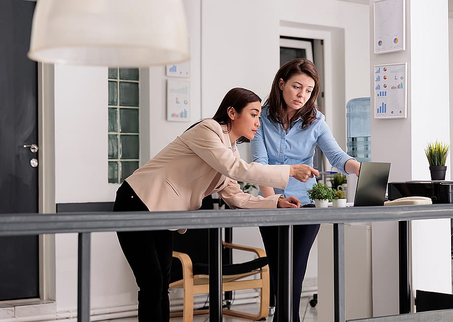 Two female coworkers discussing a company report. — DC Studio // Shutterstock