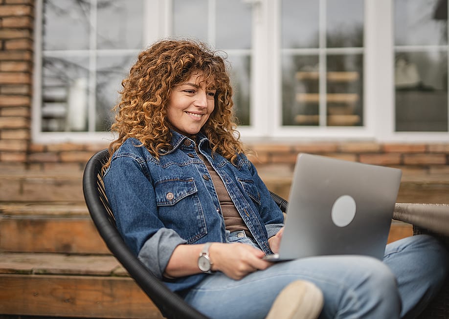 Woman sitting at home while browsing information using a laptop. — Miljan Zivkovic // Shutterstock